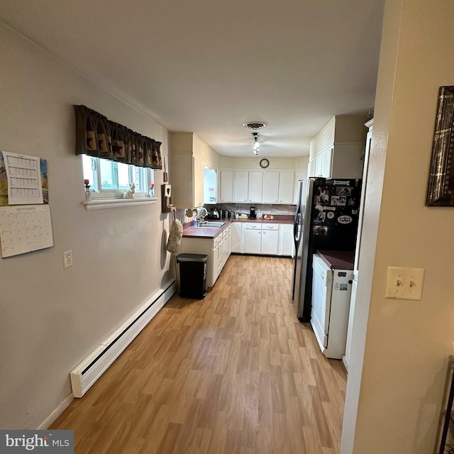 kitchen with white range, sink, white cabinets, light hardwood / wood-style flooring, and baseboard heating