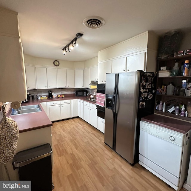 kitchen with light wood-type flooring, black appliances, white cabinetry, and sink