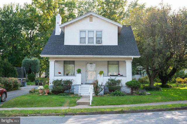 view of front of house featuring a front lawn and covered porch