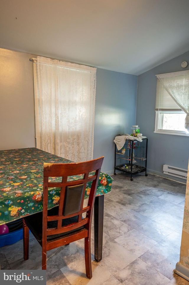 dining room with vaulted ceiling and a baseboard heating unit