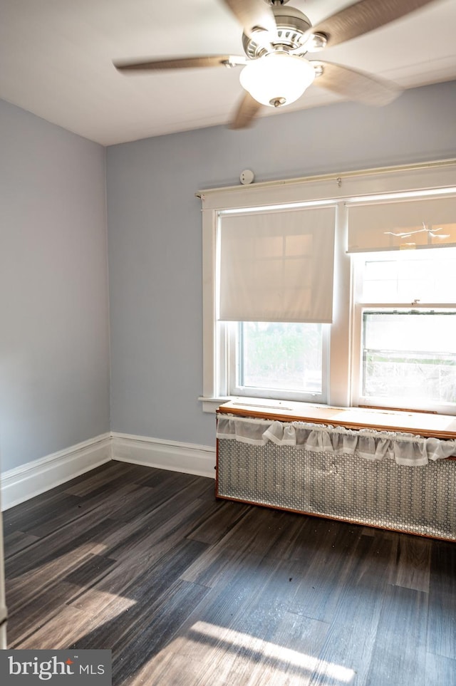 unfurnished room featuring ceiling fan and dark wood-type flooring