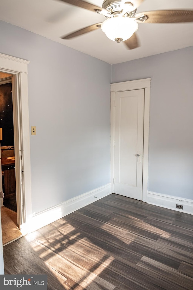 empty room with dark wood-type flooring and ceiling fan