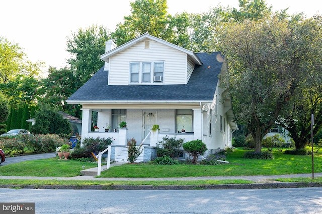 view of front of home featuring a front yard and covered porch