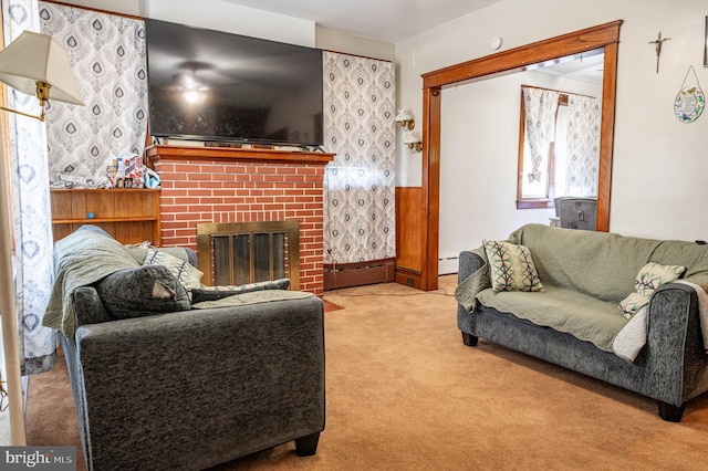 carpeted living room with a fireplace and a baseboard heating unit