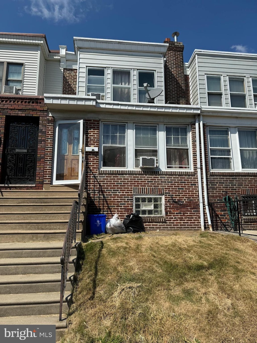 townhome / multi-family property featuring a front yard and cooling unit