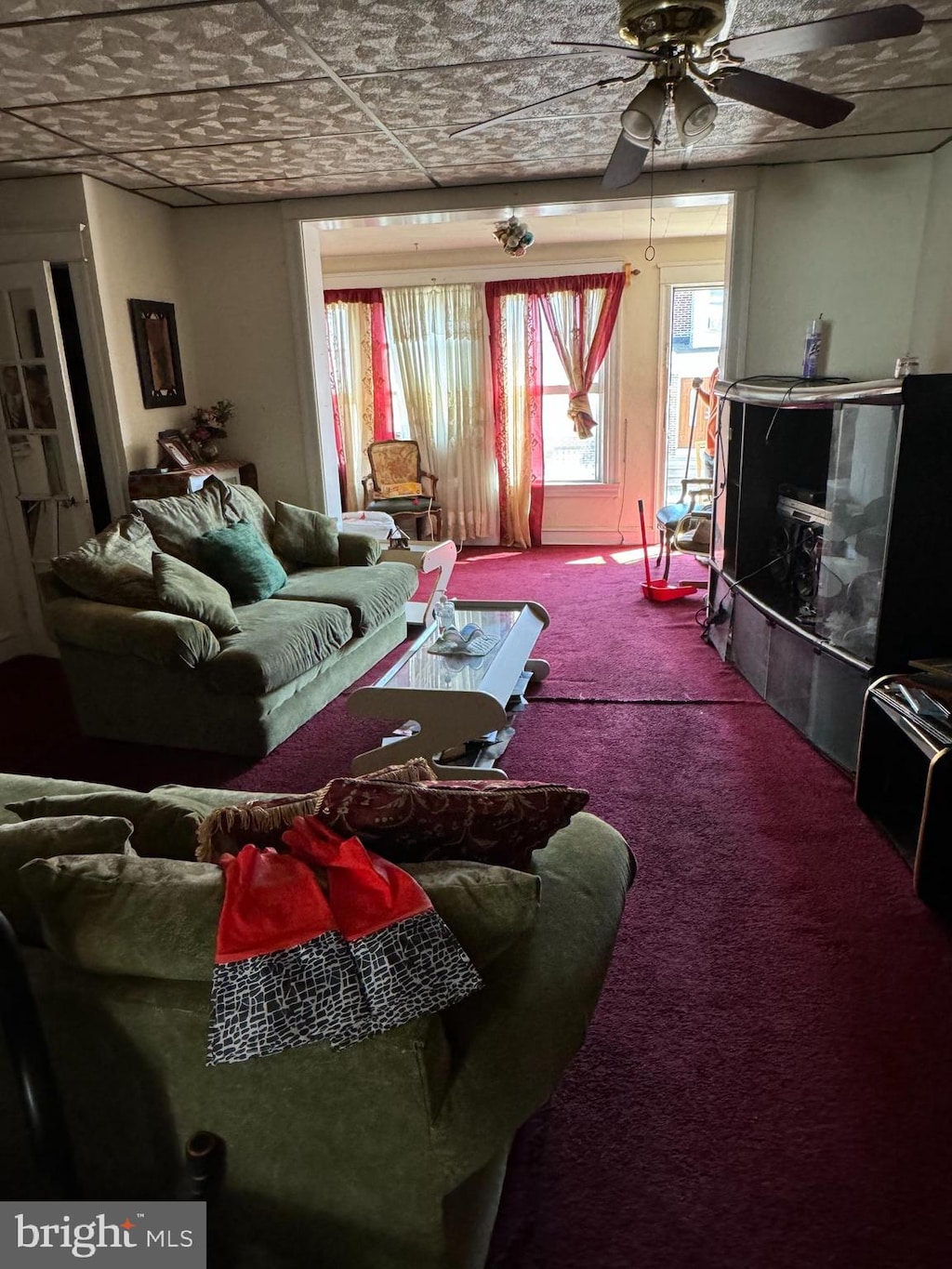 living room with carpet, ceiling fan, and a fireplace