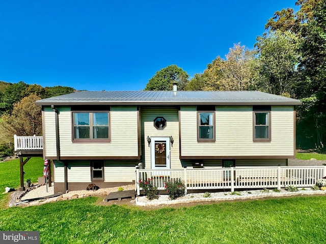 split foyer home featuring a front yard, a wooden deck, and metal roof