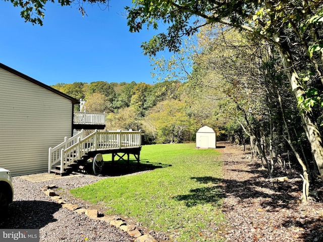 view of yard featuring a storage unit and a wooden deck