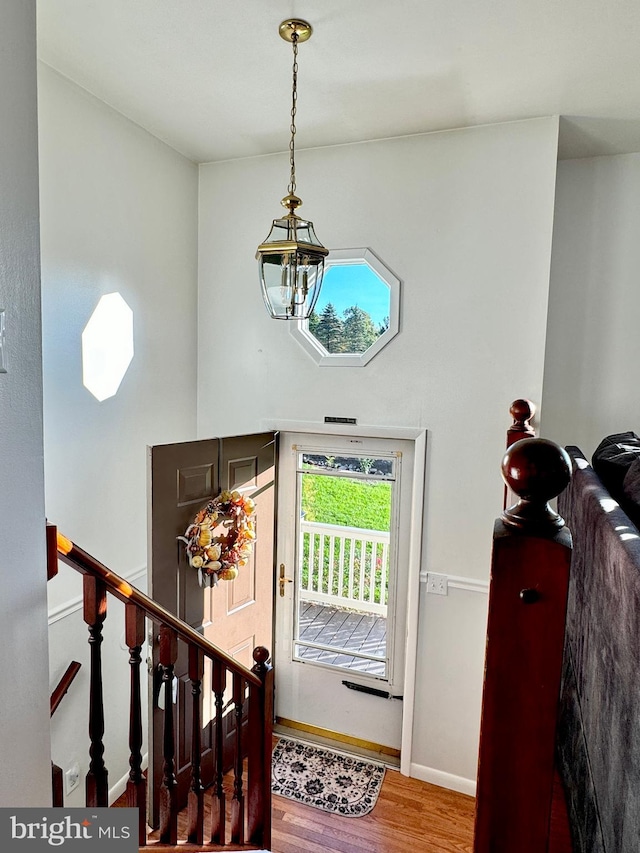 entryway with hardwood / wood-style flooring and a chandelier