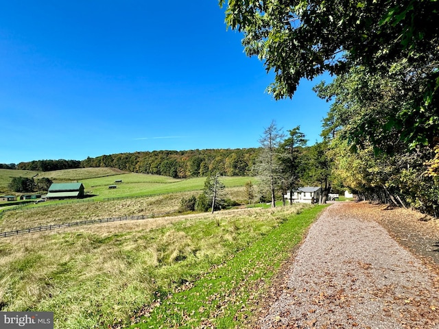view of property's community featuring a rural view and a view of trees