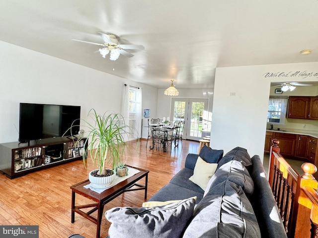 living area featuring light wood-style flooring and a ceiling fan