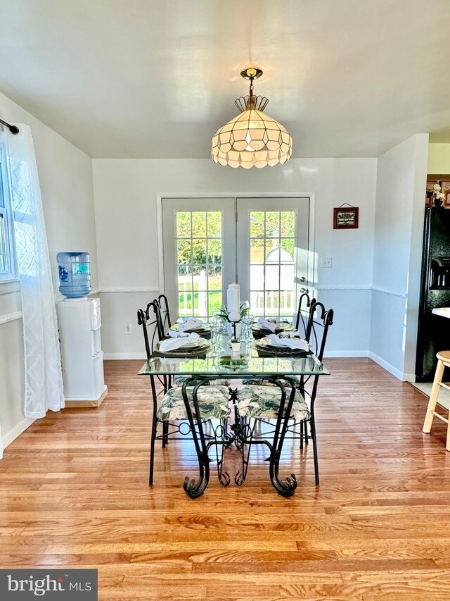 dining area with light wood-style floors and baseboards