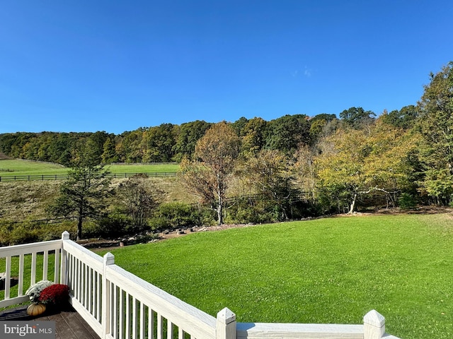 view of yard with a rural view and a wooden deck