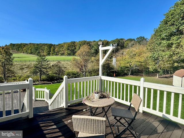 deck with a yard and a forest view