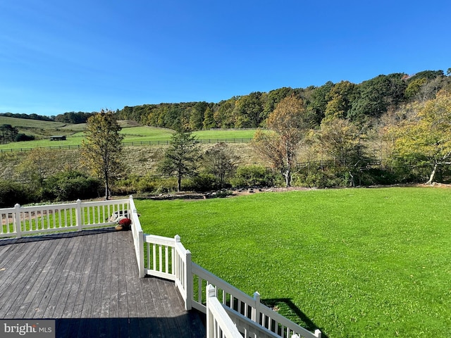 view of yard with a rural view and a deck