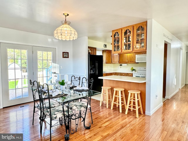 dining space with light wood-type flooring, baseboards, and visible vents