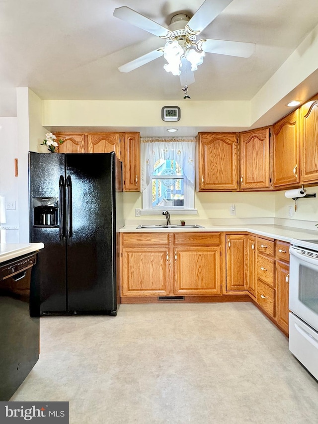 kitchen with light countertops, a ceiling fan, black appliances, visible vents, and a sink