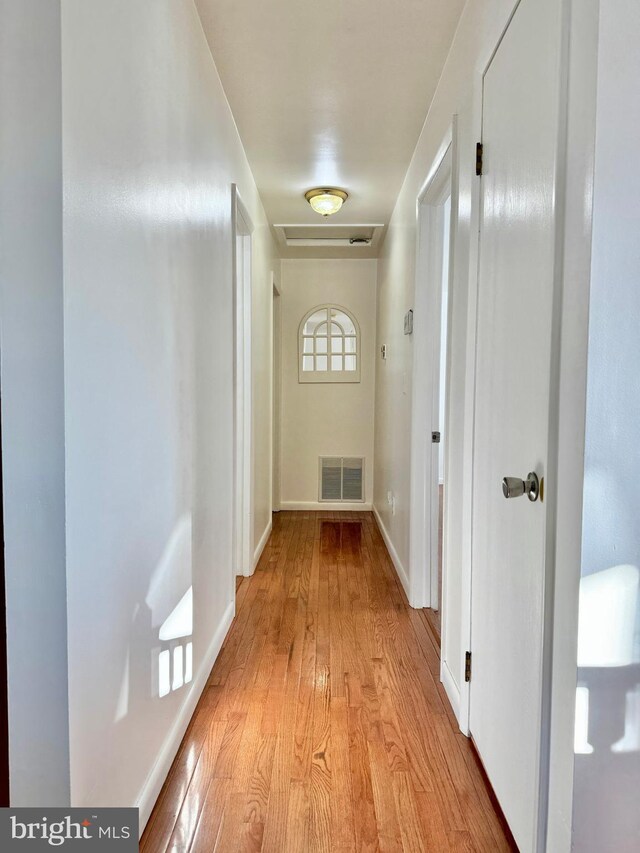 corridor with visible vents, baseboards, and light wood-type flooring