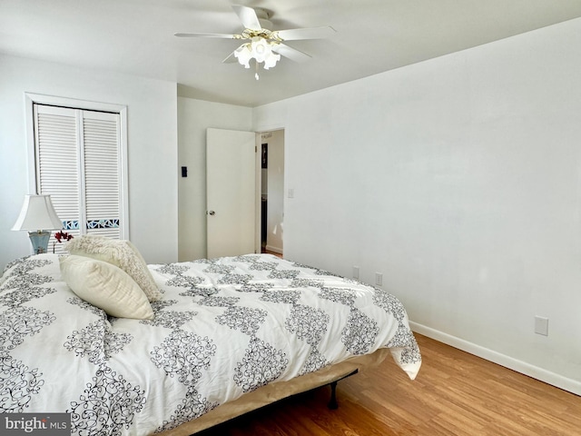 bedroom with hardwood / wood-style floors, ceiling fan, and a closet