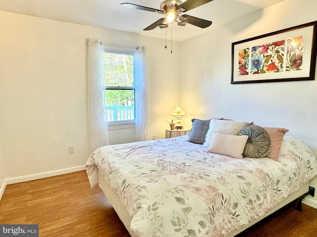 bedroom with baseboards, a ceiling fan, and wood finished floors