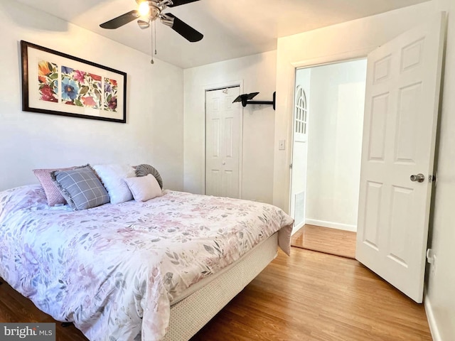 bedroom with a closet, wood-type flooring, and ceiling fan