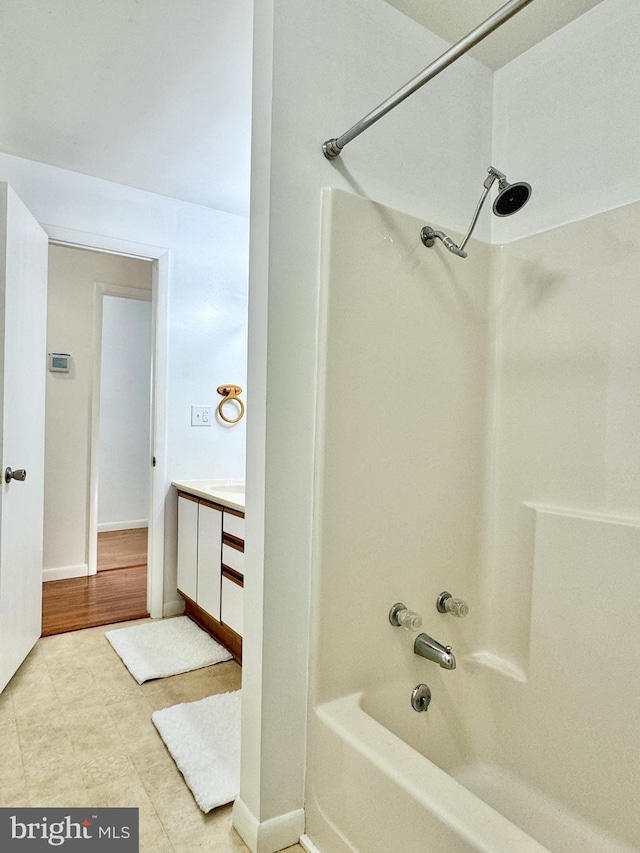 bathroom with bathtub / shower combination, hardwood / wood-style flooring, and vanity