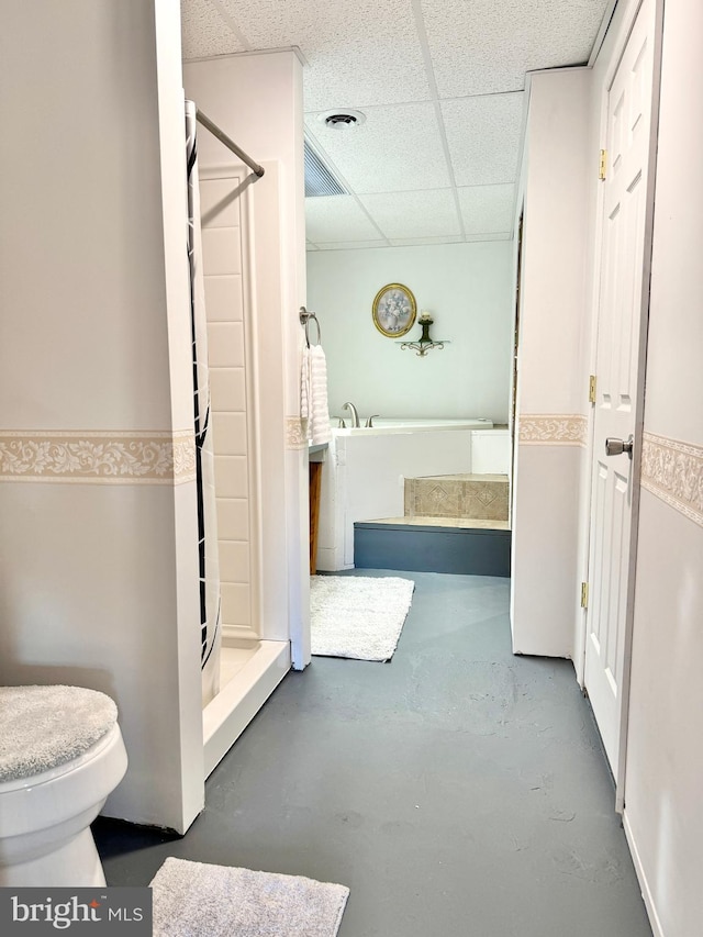 bathroom featuring a paneled ceiling, toilet, a shower with shower curtain, and concrete floors