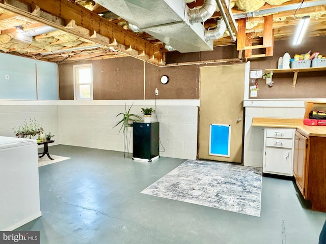 basement featuring washer / dryer and concrete block wall