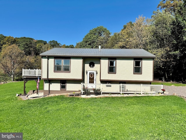 bi-level home with a front lawn and metal roof