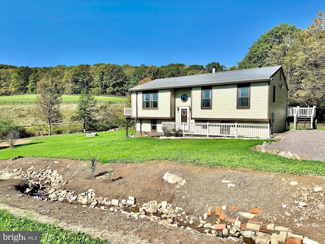 raised ranch featuring a front yard and metal roof