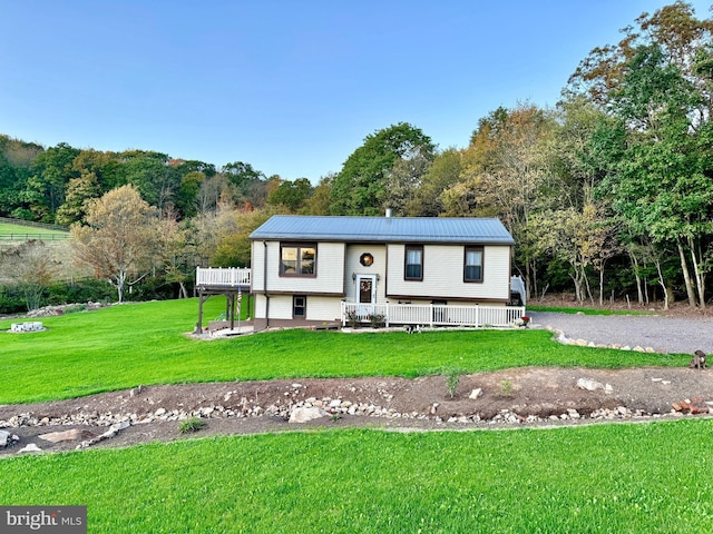 bi-level home featuring a front yard and metal roof