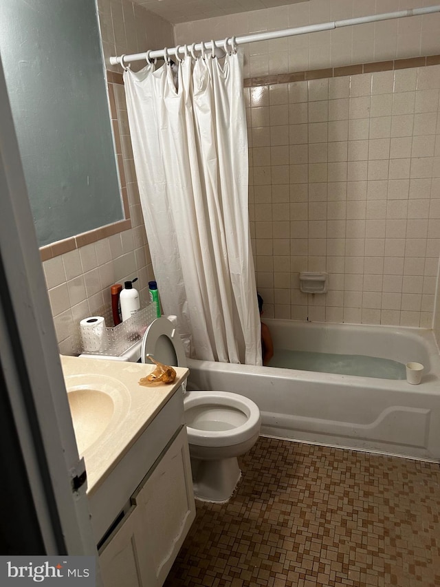 full bathroom featuring tile walls, vanity, toilet, and shower / bathtub combination with curtain