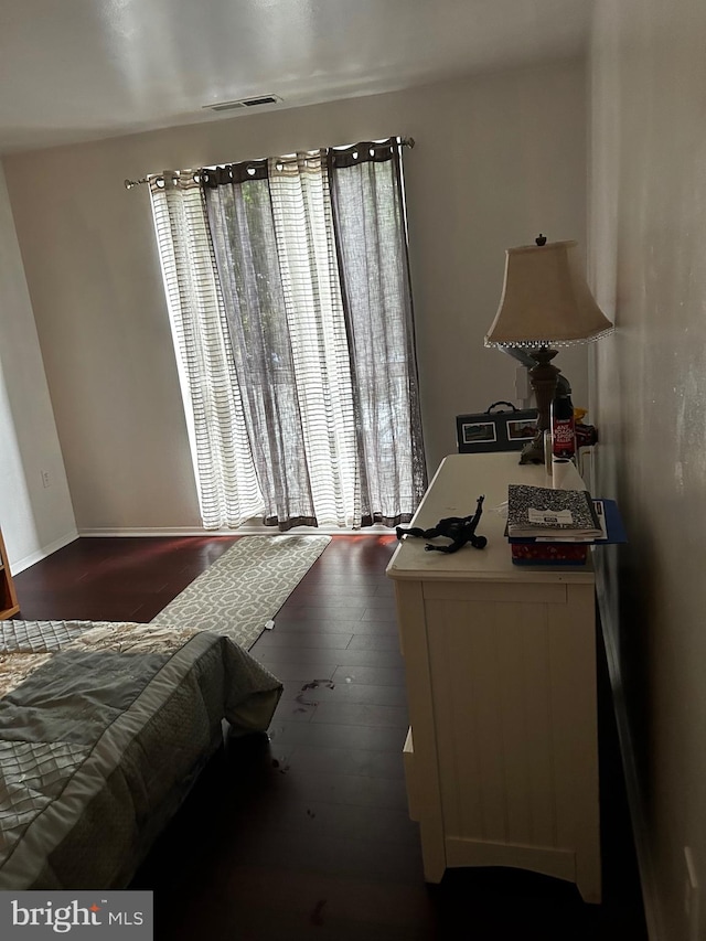 bedroom with dark hardwood / wood-style floors