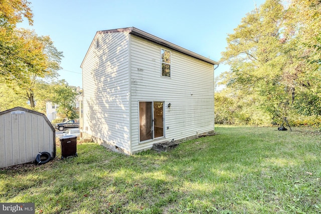 back of property with a storage shed and a lawn