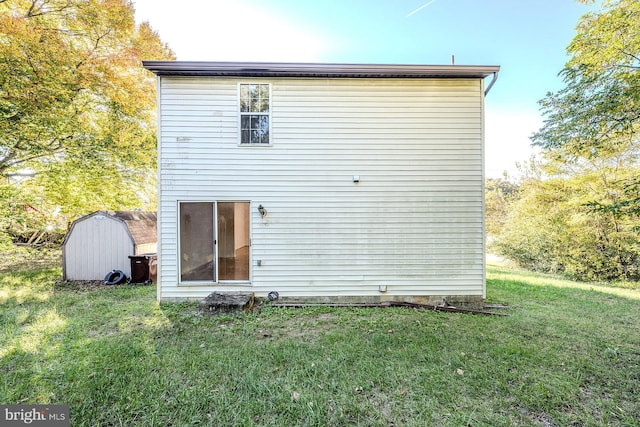 back of house with a lawn and a storage unit