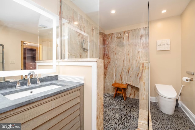 bathroom with a tile shower, tile patterned flooring, vanity, and toilet