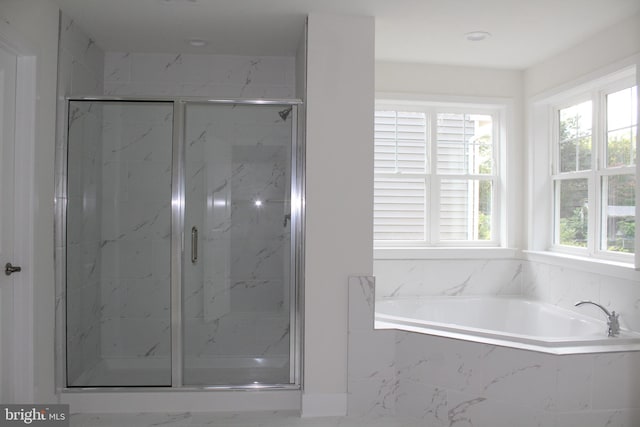 bathroom featuring independent shower and bath and plenty of natural light