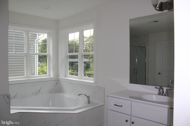 bathroom featuring vanity, separate shower and tub, and a wealth of natural light