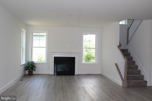 unfurnished living room featuring hardwood / wood-style flooring and a wealth of natural light