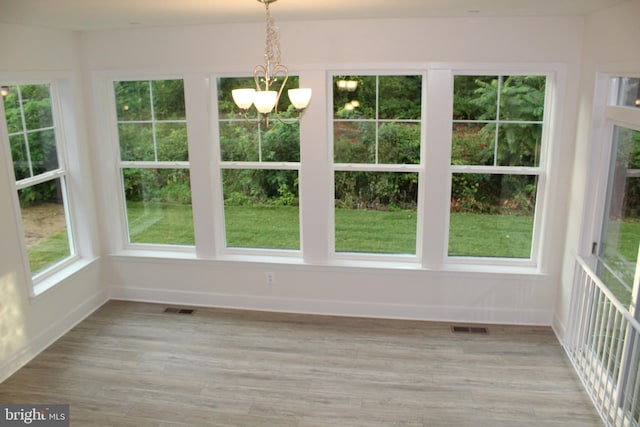 unfurnished sunroom featuring an inviting chandelier and plenty of natural light