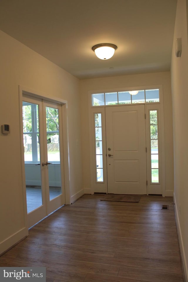 foyer entrance with french doors and dark wood-type flooring