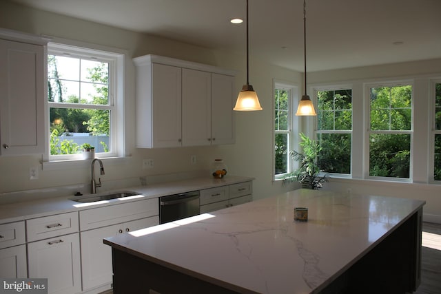 kitchen with hanging light fixtures, white cabinetry, dishwasher, a center island, and sink