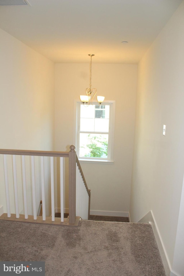 staircase with carpet and an inviting chandelier