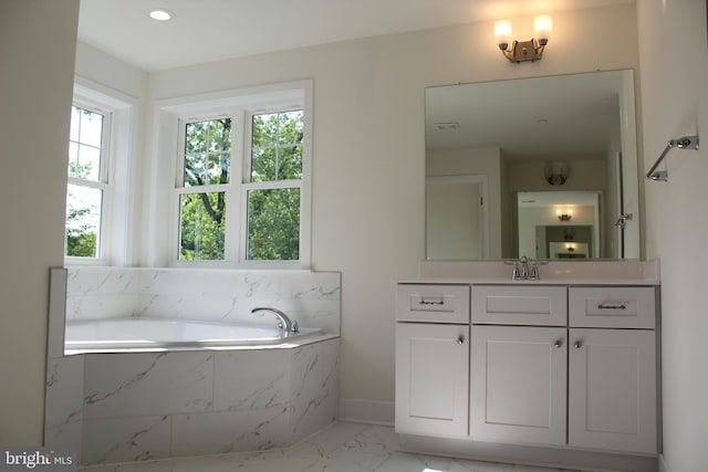 bathroom with tiled bath and vanity