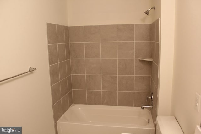 bathroom featuring tiled shower / bath combo and toilet