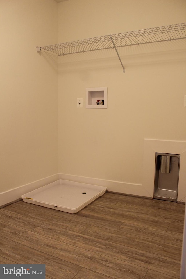 clothes washing area featuring hardwood / wood-style floors and washer hookup