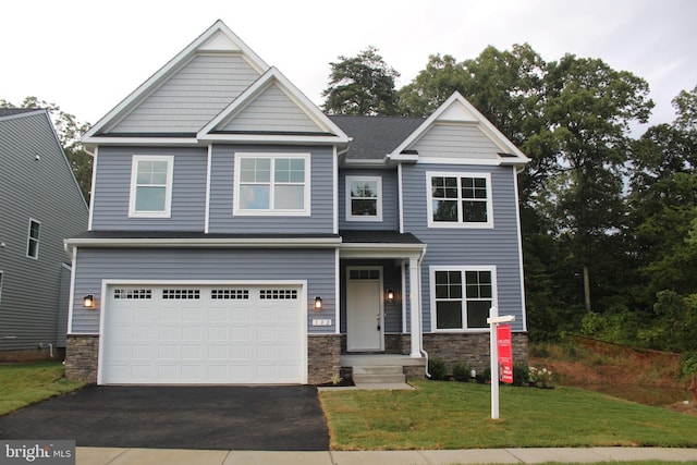 craftsman house featuring a front yard and a garage