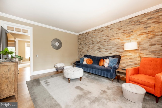 living room featuring ornamental molding, wood-type flooring, and brick wall