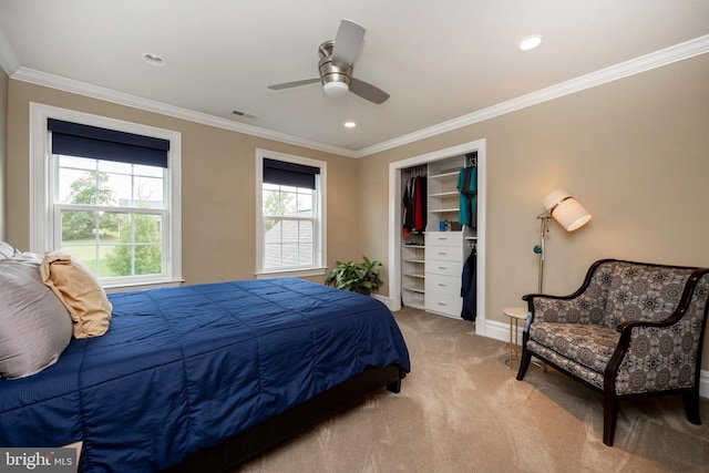 bedroom with ornamental molding, a closet, ceiling fan, and light colored carpet