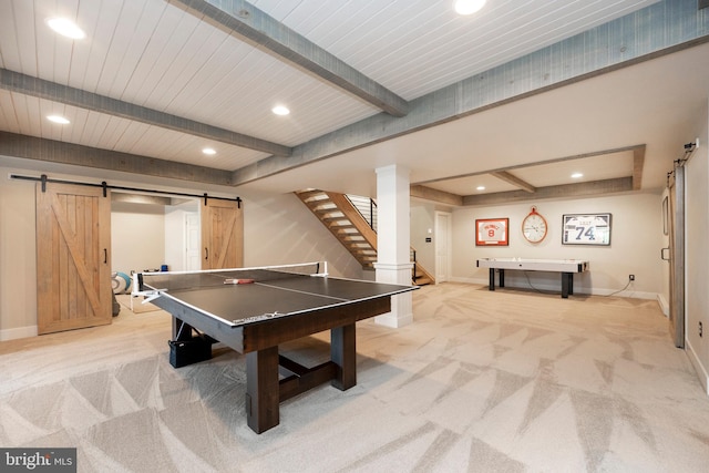 recreation room featuring beam ceiling, light colored carpet, and a barn door